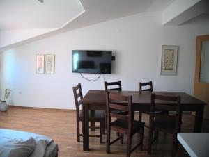 uma sala de jantar com mesa e cadeiras e uma televisão em ParkView Complex Large Flat Next to Ski Lift em Bansko
