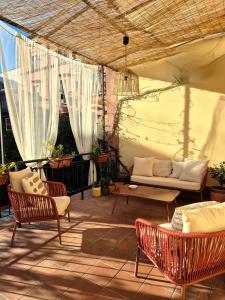 een patio met stoelen, een bank en een tafel bij La Terrazza al Museo in Napels