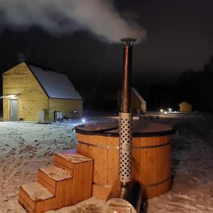 a wood stove in front of a building at night at Domek na Roztoczu Sauna & Jacuzzi in Horyniec
