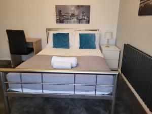 a bedroom with a large bed with blue pillows at Roomstay Hemel in Hemel Hempstead