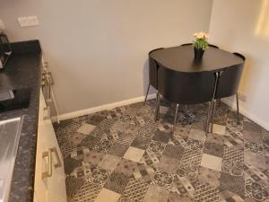 a table with a vase of flowers on top of a floor at Roomstay Hemel in Hemel Hempstead