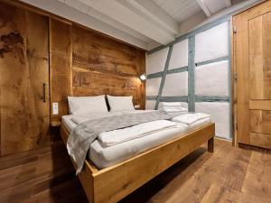 een slaapkamer met een groot bed en een groot raam bij Goldbachmühle Fewo Kornhaus in Überlingen