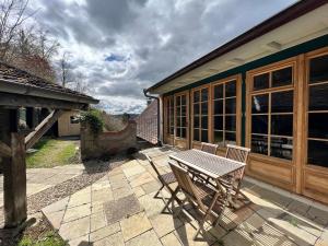 een patio met een tafel en stoelen en een gebouw bij Goldbachmühle Fewo Kornhaus in Überlingen