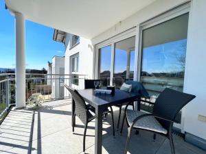 a patio with a table and chairs on a balcony at Ferienwohnung am Tobelbach in Überlingen