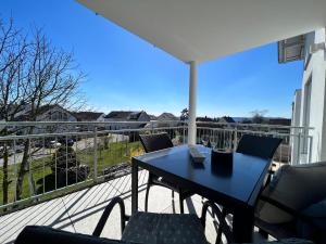 a table and chairs on a balcony with a view at Ferienwohnung am Tobelbach in Überlingen