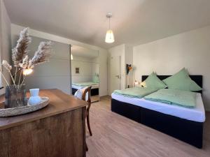 a bedroom with a bed and a table in a room at Ferienwohnung am Tobelbach in Überlingen