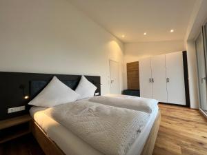 a bedroom with a large bed and white cabinets at Landhaus zum See - Fewo Birke in Überlingen