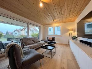 een woonkamer met een bank en een tv bij STAY in Uhldingen-Mühlhofen