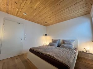een slaapkamer met een bed en een houten plafond bij STAY in Uhldingen-Mühlhofen