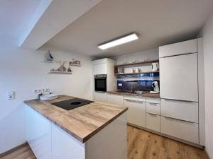 a kitchen with white cabinets and a wooden counter top at SEEglück in Allensbach