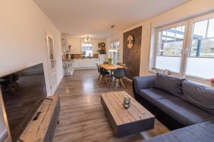 a living room with a couch and a table at Ferienhaus Meerträume in Pewsum
