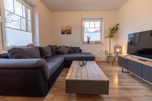 a living room with a couch and a coffee table at Ferienhaus Meerträume in Pewsum