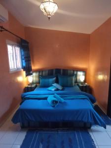1 dormitorio con cama azul y manta azul en RIAD Anis en Marrakech