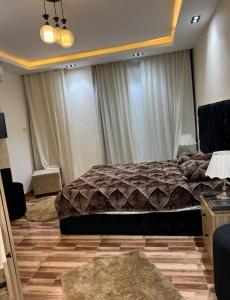 a bedroom with a large bed and curtains at شقة فندقية غرفتين للايجار بالمهندسين in Cairo