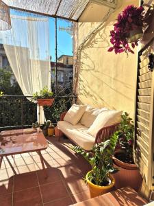 een patio met een bank en een tafel op een balkon bij La Terrazza al Museo in Napels