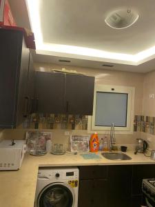 a kitchen with a washing machine and a sink at شقة فندقية غرفتين للايجار بالمهندسين in Cairo