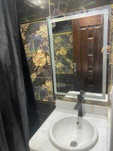 a bathroom with a sink and a mirror at شقة فندقية غرفتين للايجار بالمهندسين in Cairo