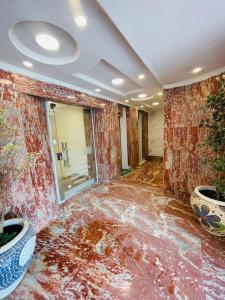 a room with a red marble floor with plants at شقة فندقية غرفتين للايجار بالمهندسين in Cairo