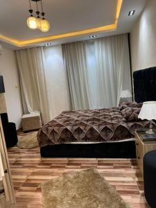 a bedroom with a large bed and two windows at شقة فندقية غرفتين للايجار بالمهندسين in Cairo