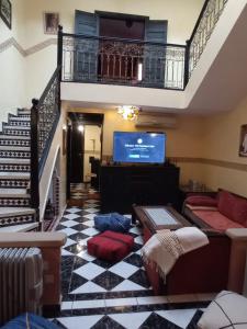 Il comprend un salon avec un escalier et une télévision. dans l'établissement RIAD Anis, à Marrakech