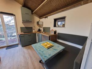 a kitchen with a table in the middle of a room at Petite maison vue sur Lac de la Triouzoune Neuvic in Neuvic +22 photos