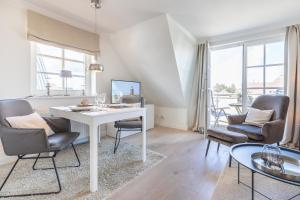 ein Wohnzimmer mit einem weißen Tisch und Stühlen in der Unterkunft Hingst, App. 3 Nettes Neest in Wenningstedt-Braderup