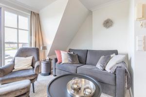ein Wohnzimmer mit einer Couch und zwei Sesseln in der Unterkunft Hingst, App. 3 Nettes Neest in Wenningstedt-Braderup