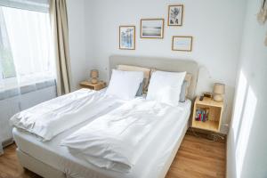 1 dormitorio con 1 cama blanca con sábanas y almohadas blancas en City Apartments Gerlingen en Gerlingen