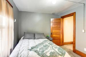 1 dormitorio con 1 cama y puerta de madera en Historic Tiffin Home about Half Mi to University!, en Tiffin