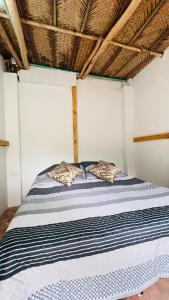- un lit dans une petite chambre avec un toit dans l'établissement Cabaña la roca de minca sierra nevada, à Santa Marta