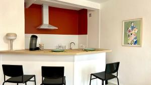a kitchen with black chairs and a counter top at Le Terracotta in Nevers