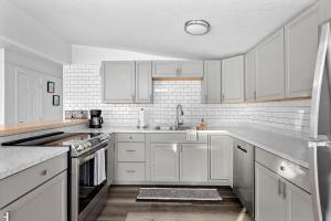 a white kitchen with white cabinets and a sink at Bright & Stylish 2 Bedroom Home in Missoula