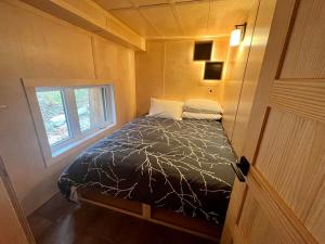uma cama num pequeno quarto com uma janela em Cabin Zoobox 76 em Eastman