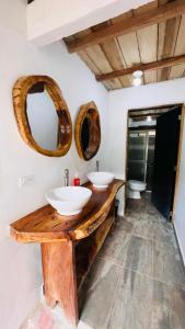 ein Badezimmer mit zwei Waschbecken und zwei Spiegeln an der Wand in der Unterkunft Cabaña la roca de minca sierra nevada in Santa Marta