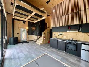 - une grande cuisine avec des appareils noirs et des murs en bois dans l'établissement Cabin Zoobox 79, à Eastman