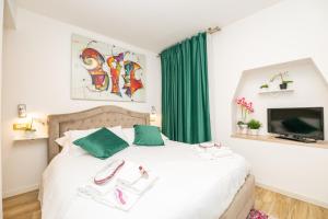 Schlafzimmer mit einem Bett mit grünen Vorhängen und einem TV in der Unterkunft Isa Sweet Home in Venedig