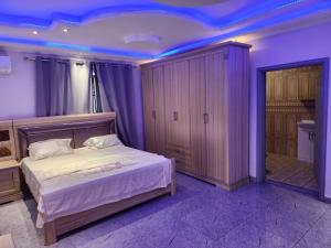 ein Schlafzimmer mit einem großen Bett mit violetter Beleuchtung in der Unterkunft Medi Square Lodge in Freetown