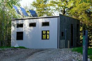 una piccola casa con pannelli solari sopra di Cabin Zoobox 80 a Eastman