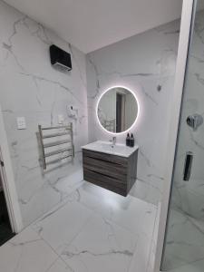 a white bathroom with a sink and a mirror at Lakeview Colonial House in Queenstown