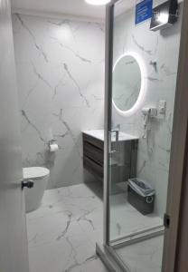 ein Bad mit einer Dusche, einem WC und einem Spiegel in der Unterkunft Lakeview Colonial House in Queenstown