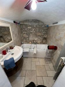 a bathroom with a white tub and a sink and a bath tub at Maison de 6 pièces au coeur du village d'Eze in Èze
