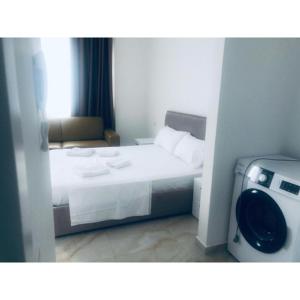 a hotel room with a bed and a washing machine at Real Resort Albania in Fushë-Draç