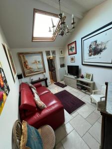 a living room with a red leather couch and a tv at Maison de 6 pièces au coeur du village d'Eze in Èze