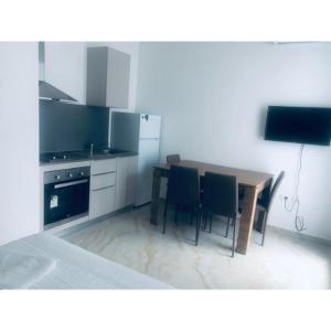 a kitchen with a table and chairs and a television at Real Resort Albania in Fushë-Draç