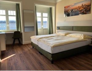 Schlafzimmer mit einem Bett, einem Schreibtisch und Fenstern in der Unterkunft Hotel Pickwick and Pub "the room with a view" in Luzern