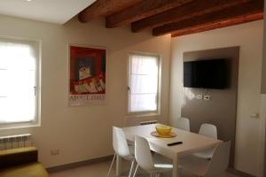 uma sala de jantar branca com uma mesa e cadeiras brancas em Iris House em Chioggia