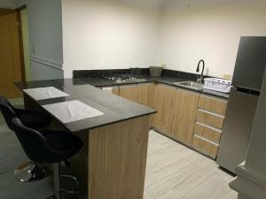 a kitchen with a counter with a sink and a refrigerator at Departamento 2 habitaciones in Chitré