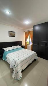 Un dormitorio con una cama grande y una ventana en VP Casa Condominio con Aire Acon, en Neiva