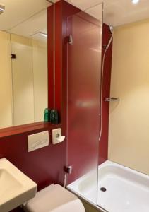 La salle de bains est pourvue d'une douche, de toilettes et d'un lavabo. dans l'établissement Hotel Pickwick and Pub "the room with a view", à Lucerne