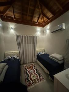 a small room with two beds and a rug in it at Locação Terras de São Francisco, Quarto Flamboyant in Andradas